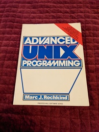 Advanced UNIX Programming book cover. White cover with the words ADVANCED UNIX PROGRAMMING in large blue and white letters and a red stripe in the upper-right corner