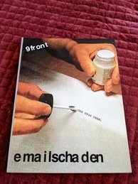 Cover of the 9front Dash1 manual, emailschaden. Features an image of a large piece of paper with the phrase 'THE UPAS TREE.' apparently typed on it, while someone is preparing to use some correction fluid to the text.