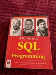 Beginning SQL Programming book cover. It's very red with giant yellow letters announcing the title. The authors are pictured across the top in rather unflattering black and white images.
