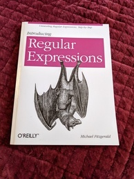 Introducing Regular Expressions book cover from O'Reilly. Features an image of a fruit bat with its young hanging off of the logo