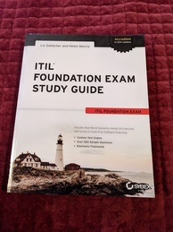 ITIL Foundation Exam Study Guide book cover. Features a lighthouse and a few assorted buildings on a beach overlooking a body of water