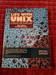 Life with UNIX book cover. Mostly covered with an irregular blue geometric pattern, with a red geometric pattern on the bottom-right corner.