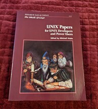 Cover of the UNIX Papers for UNIX Developers and Power Users book by the Waite Group. Features a drawing of five old men in elaborate robes decorated with scallop shells. One man is seated at a desk writing using a quill and has an inkwell of glowing green ink. There is an open book in front of him and several papers scattered around. The rest of the men look on with one man holding an open book and a rod of some kind 