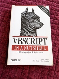 Cover of the VBScript in a Nutshell O'Reilly book. Features an image of the head of a miniature pinscher