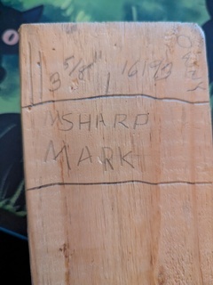 Some writing samples on a piece of wood